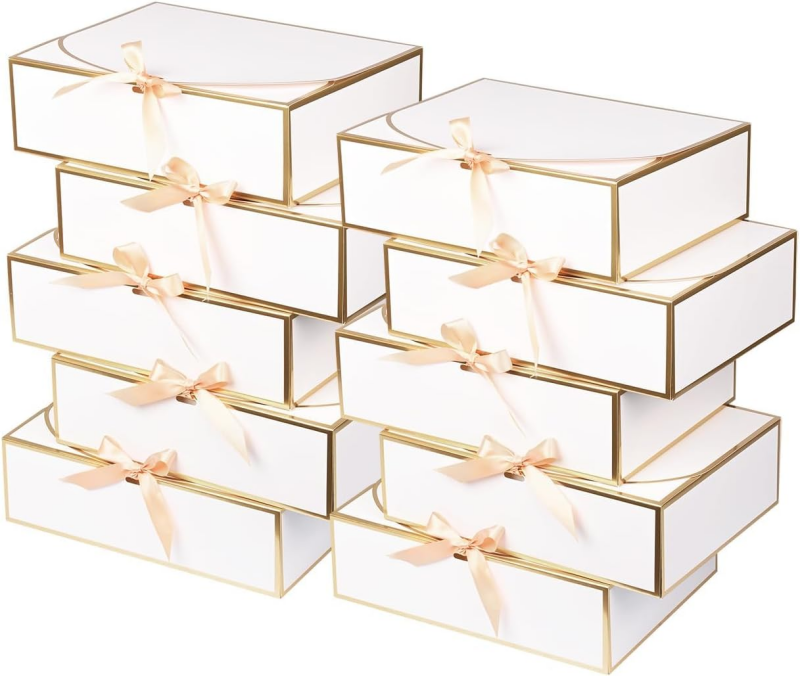 Elegant white gift boxes with gold trim and a soft satin bow