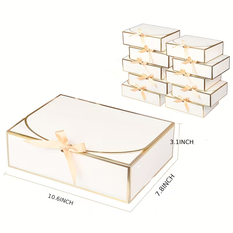 Elegant white gift boxes with gold trim and a soft satin bow